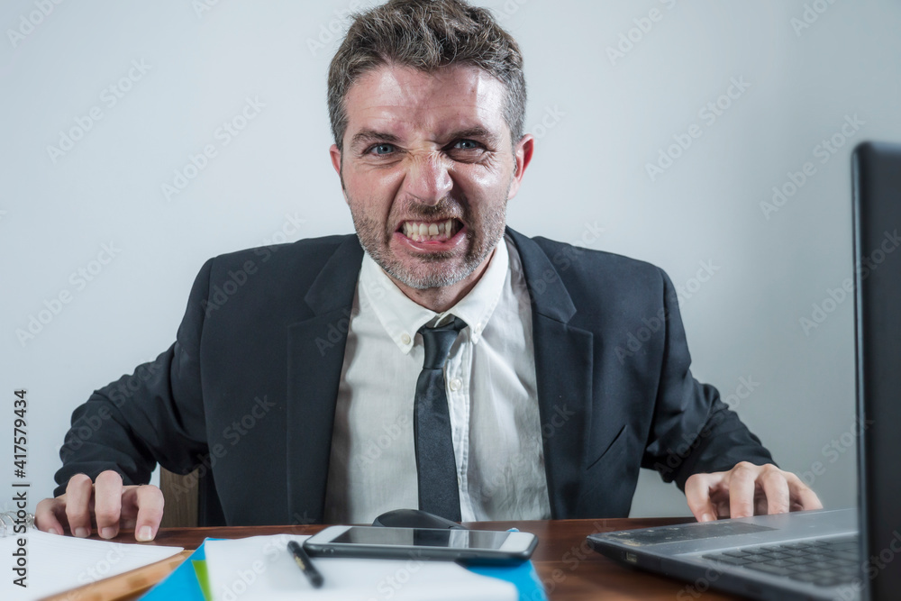 upset and angry businessman at computer desk in office- unhappy man working frustrated suffering stress as employee of corporate business complaining in rage upset and angry businessman at computer desk in office- unhappy man working frustrated suffering stress as employee of corporate business complaining in rage