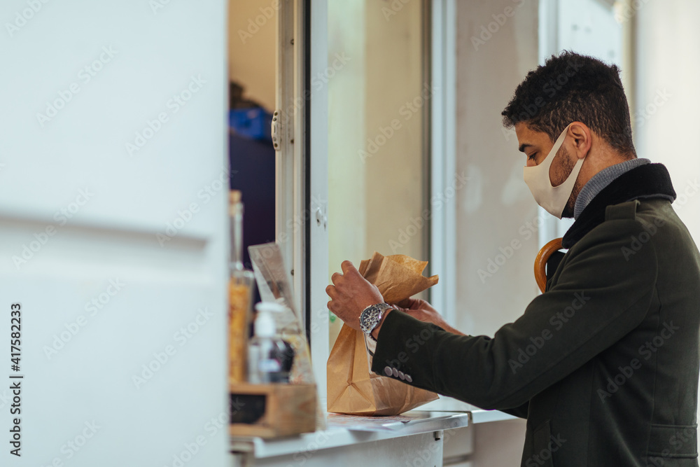Male taking paper packages of food