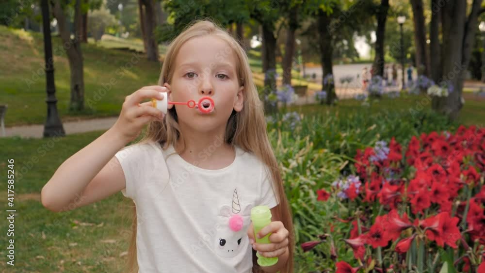 little girl blowing soap bubbles in summer park. Happy child kid outdoor portrait, cute happy schoolgirl little girl blowing soap bubbles in summer park. Happy child kid outdoor portrait, cute happy schoolgirl