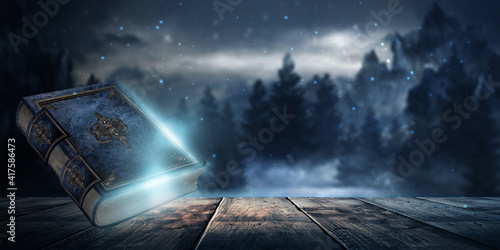 Photos Magic vintage fantasy book on a dark background, landscape, smoke, fog, neon moonlight in the dark