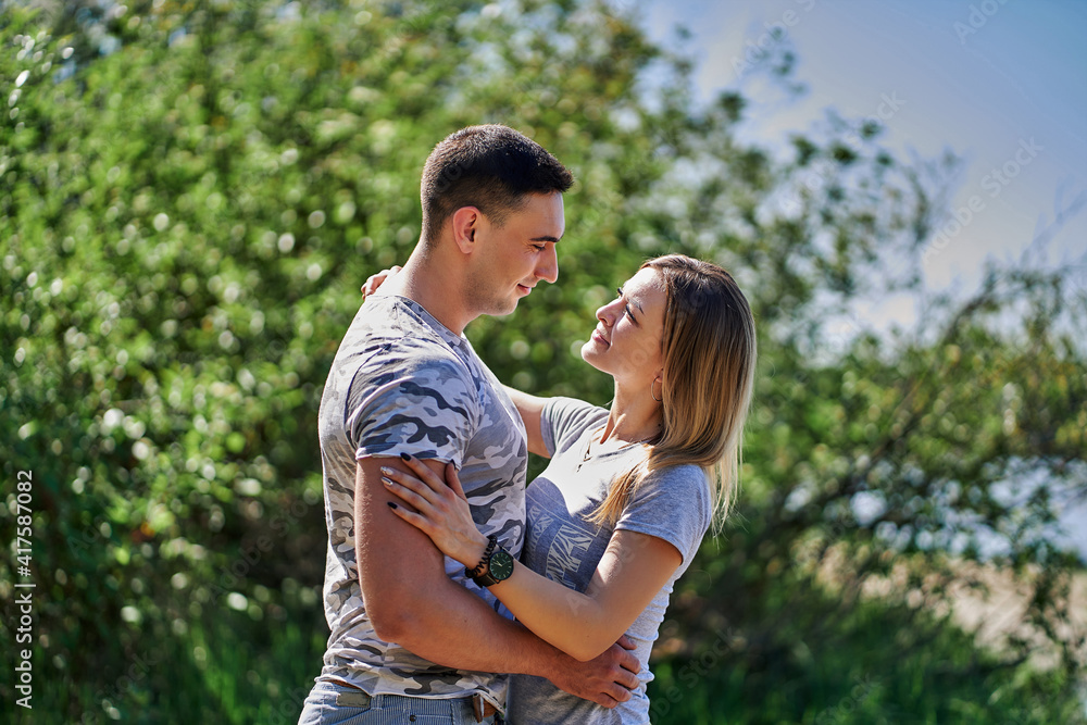 Close-up of a loving couple hugging on nature on a sunny day. Close-up of a loving couple hugging on nature on a sunny day.