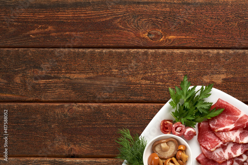 Traditional cuisine, raw ham, Italian Parma ham. Snack on a wooden table. Copy space