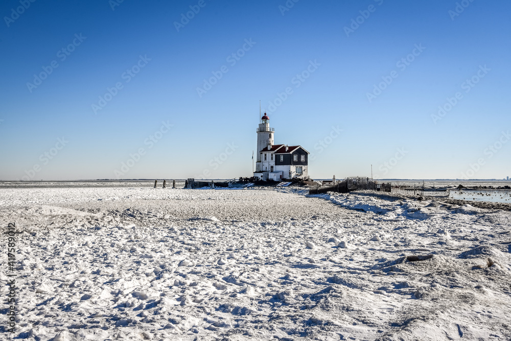 The lighthouse of Marken, 'het Paard van Marken' in winter and the frozen Markermeer, Holland.