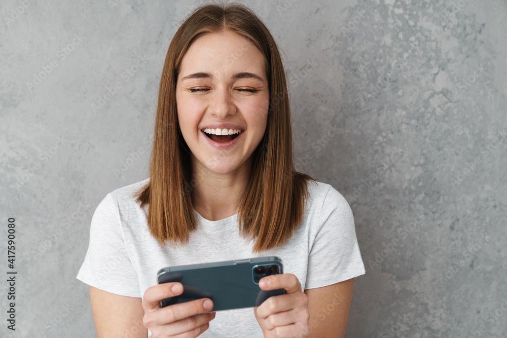 Cheerful nice charming girl laughing and using cellphone Cheerful nice charming girl laughing and using cellphone