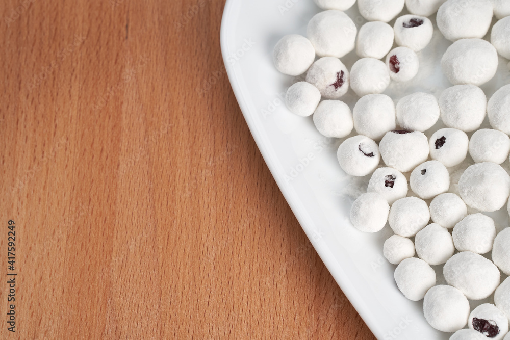 Close-up of a plate with cranberries in sugar on a wooden background. Copy space. Close-up of a plate with cranberries in sugar on a wooden background. Copy space.