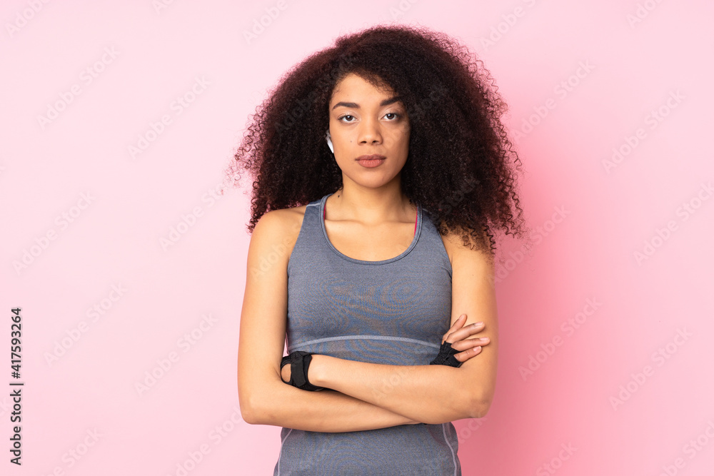 Young african american sport woman isolated on pink background with arms crossed Young african american sport woman isolated on pink background with arms crossed