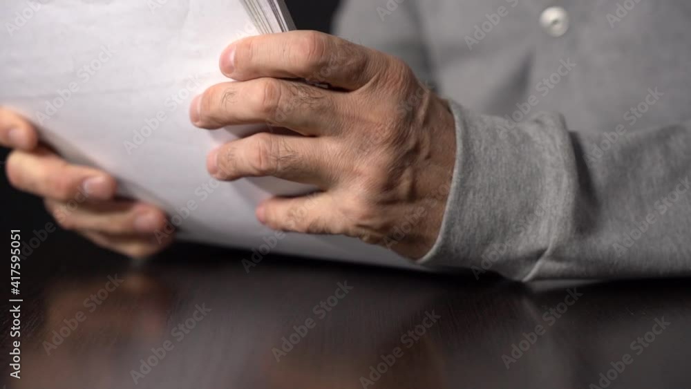Close-up. Slow motion. A Bundle of Business Papers on the Table. An Elderly Man Holds a Sheaf of Papers. Close-up. Slow motion. A Bundle of Business Papers on the Table. An Elderly Man Holds a Sheaf of Papers.