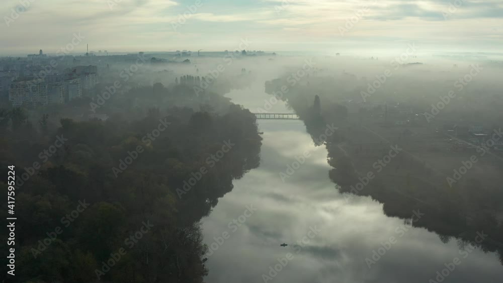 Beautiful morning, summer flight over the river. The bridge over the river in the fog, at dawn. Beautiful morning, summer flight over the river. The bridge over the river in the fog, at dawn.