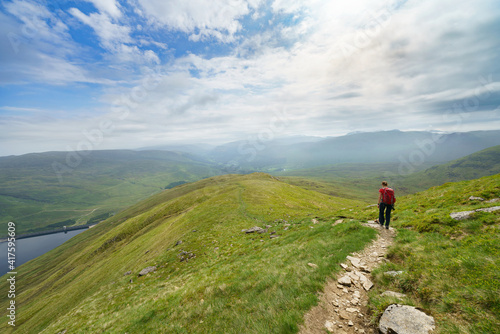 A hiker walking down from Creag an Fheadain towards Loch Daimh in the Scottish Highlands, UK mountain landscapes.