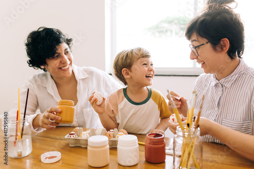 Family having fun painting eggs for Easter photo