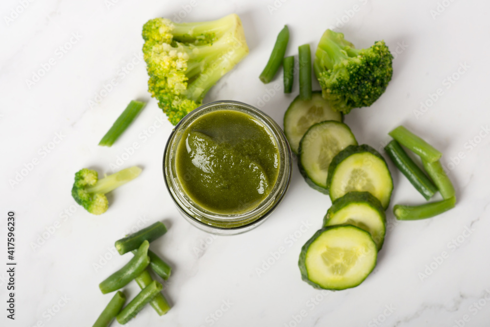 baby puree of broccoli cabbage with spoon on white background baby puree of broccoli cabbage with spoon on white background