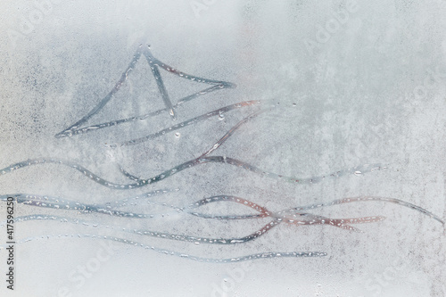 A painted boat on a fogged window