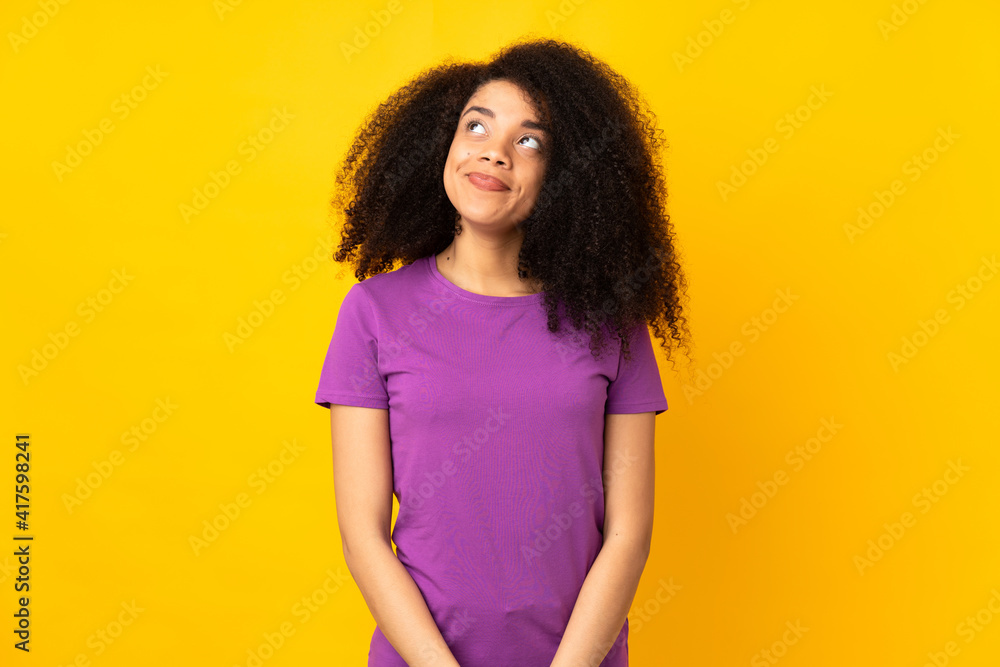 Young african american woman over isolated background having doubts while looking up Young african american woman over isolated background having doubts while looking up