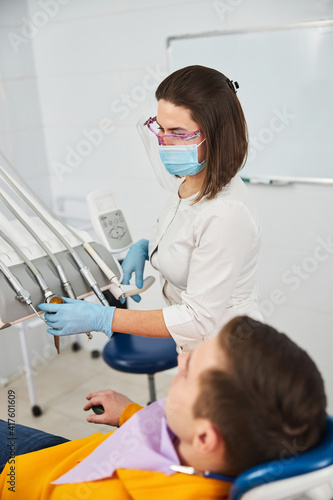 Dentist taking air turbine handpiece from instrument unit