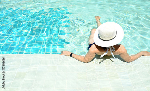 Girl relaxing in pool summer Tropical beach lifestyle.