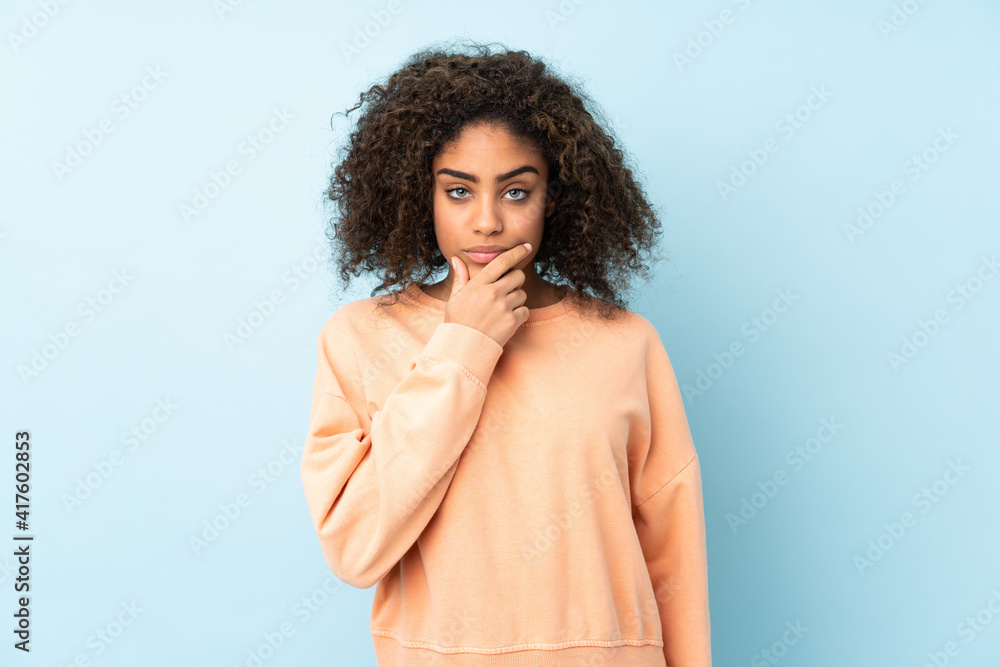 Young African American woman isolated on blue background thinking Young African American woman isolated on blue background thinking