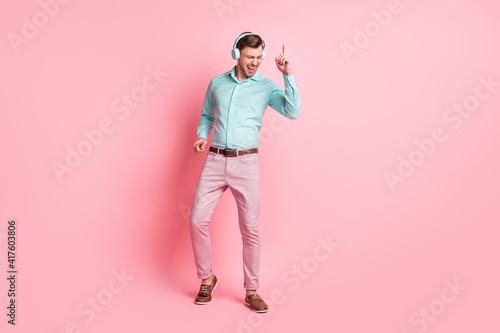 Full body photo of charming happy man dance wear headphones relax love music isolated on pastel pink color background