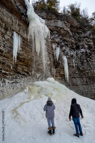 Hikers near frozen Awosting Falls, massive icicles hang from the cliffs in Minnewaska State Park in Upstate New York. USA photo