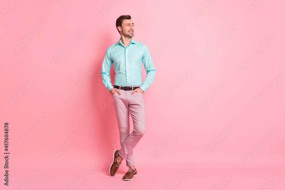 Full size photo of young handsome attractive businessman look copyspace hold hands in pockets isolated on pink color background Full size photo of young handsome attractive businessman look copyspace hold hands in pockets isolated on pink color background