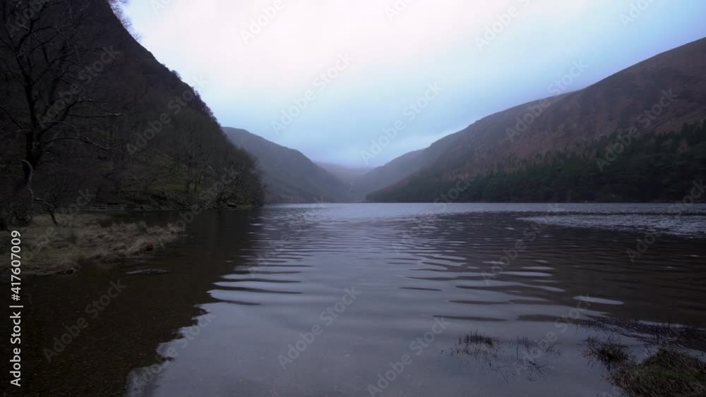 Lake in Glendalough Co. Wicklow Ireland at sunrise golden hour with snow capped mountains in the background Lake in Glendalough Co. Wicklow Ireland at sunrise golden hour with snow capped mountains in the background