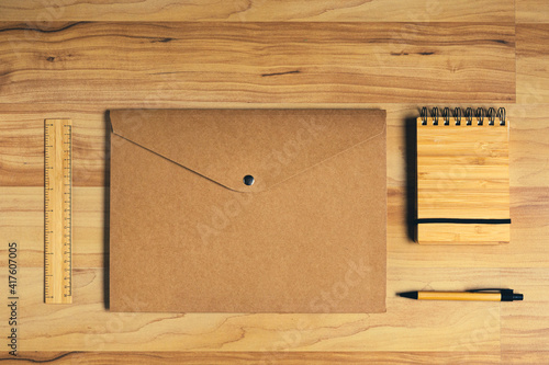 Wooden notebook and bamboo pen, recicled paper folder: sustainable office supplies for a low impact on environment photo