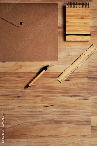 Ecofriendy office suplies: Natural wooden pen with recycled paper folder, bamboo notebook and yardstick. Wood background. sustainable and plastic free office supplies