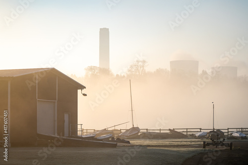 Empty abandoned sail boat club yard shrouded in fog and mist with boats sails and power station cooling tower chimneys in background at Ratcliffe-on-Soar Nottinghamshire photo