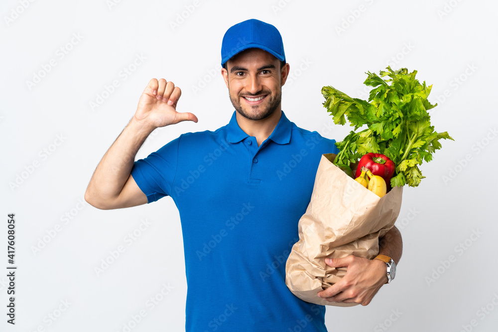 Delivery man with vegetables isolated on white background proud and self-satisfied Delivery man with vegetables isolated on white background proud and self-satisfied