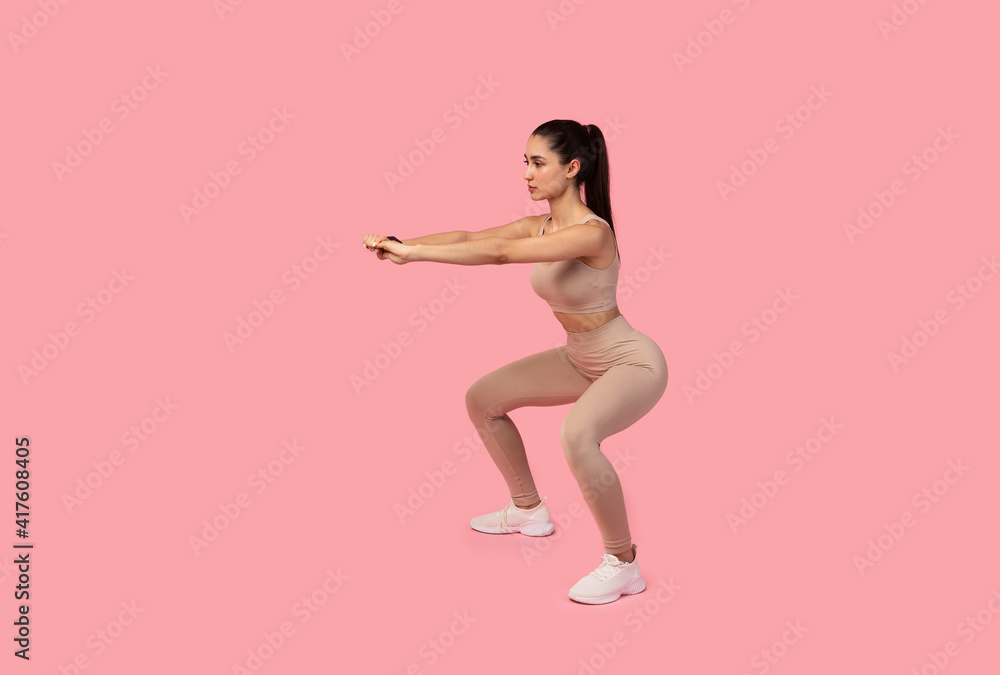 Confident Young Lady Doing Deep Squat Exercise Confident Young Lady Doing Deep Squat Exercise
