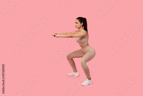 Confident Young Lady Doing Deep Squat Exercise