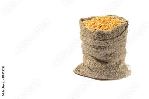 Peas in a bag, isolated on a white background.Split peas in burlap. Healthy food.Yellow split peas in a jute bag.Selective focus.
