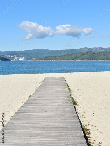 Beach with wooden boardwalk and blue sky at Rias Baixas region. Porto do Son, Coruña, Galicia, Spain.
