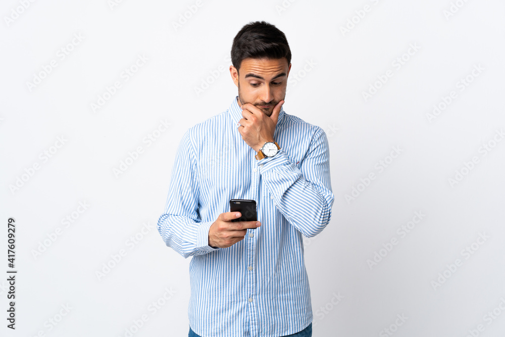 Young handsome man over isolated background thinking and sending a message Young handsome man over isolated background thinking and sending a message