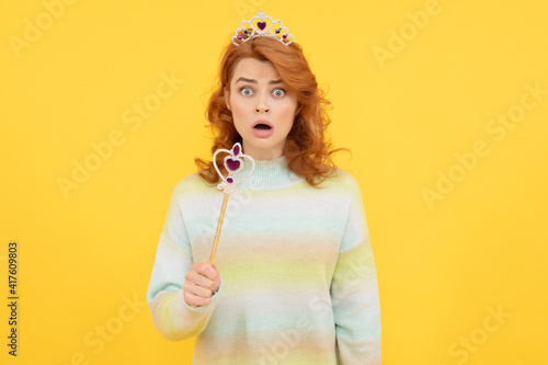 surprised redhead woman in queen crown with magic wand, surprise