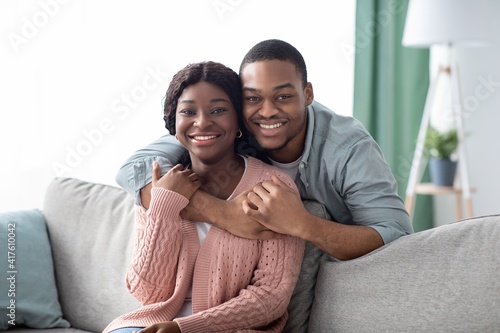 Portrait of happy black couple hugging at home