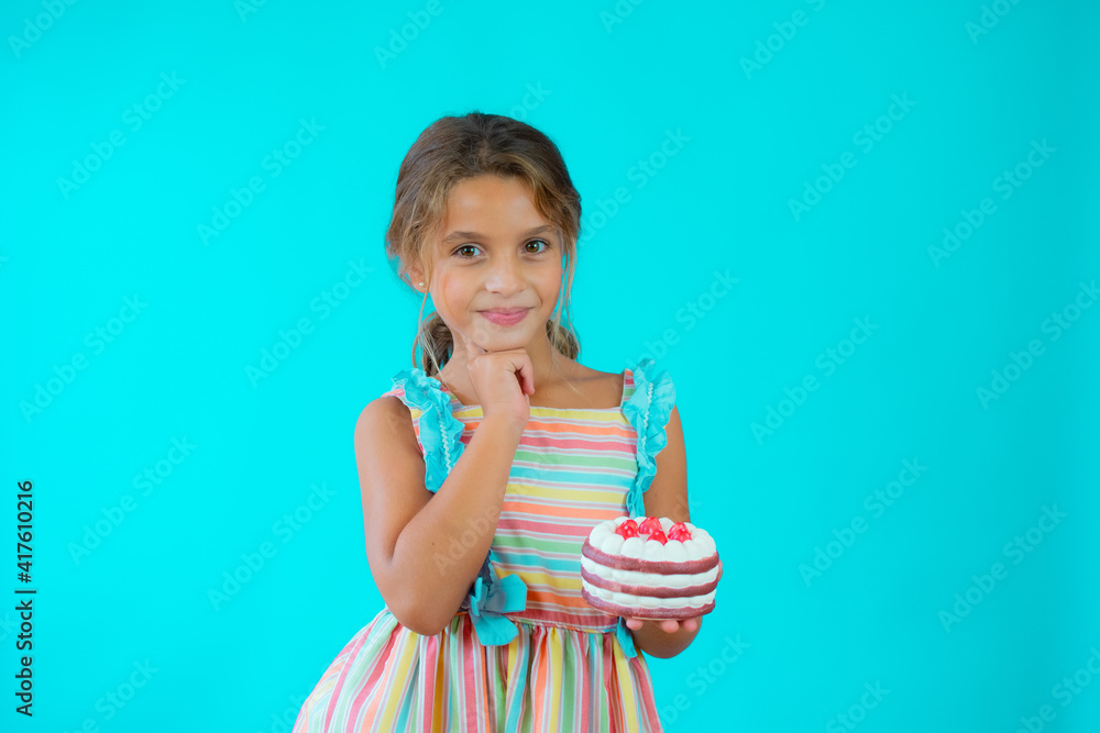 Cute adorable little girl celebrating birthday standing isolated over green background Cute adorable little girl celebrating birthday standing isolated over green background