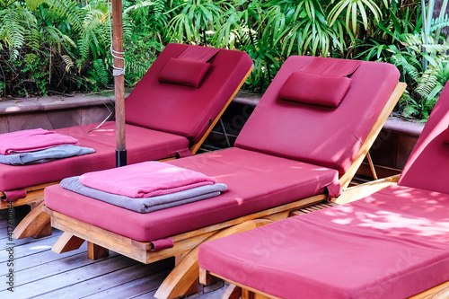 Many white chaise lounge by the pool photo