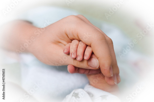 Mother holding babies hand