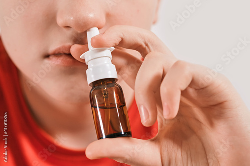 Blond Boy drips nose drops from runny nose. Treatment of colds and allergic rhinitis. Selective focus