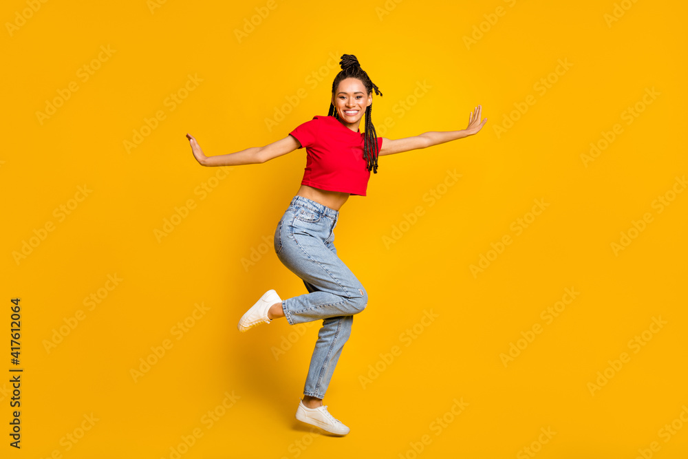 Full length body size profile side view of attractive thin cheerful girl jumping having fun isolated bright yellow color background