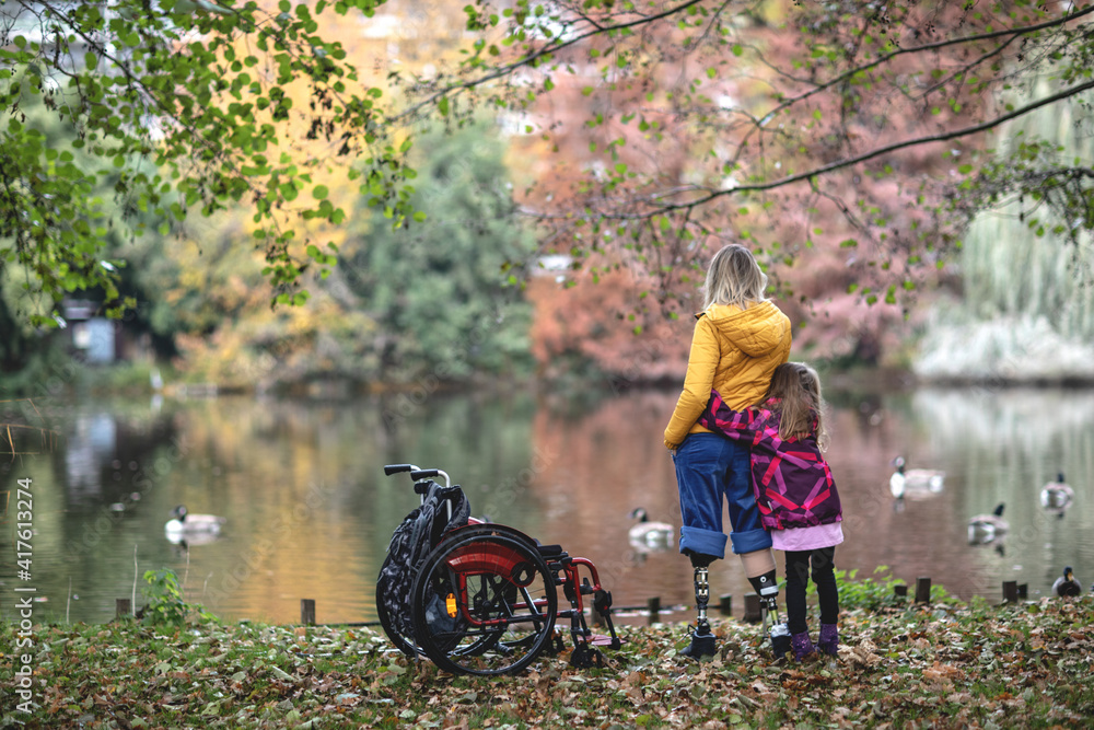 Disabled girl without legs, prostheses for legs, wheelchair, first time to stand on prostheses, disabled mother with her daughter. Disabled girl without legs, prostheses for legs, wheelchair, first time to stand on prostheses, disabled mother with her daughter.