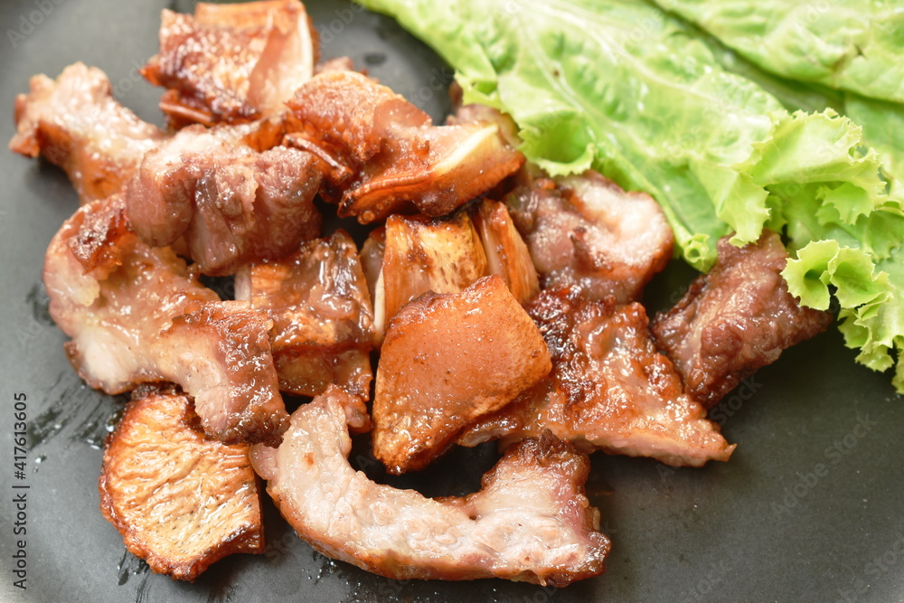 grilled pork neck and ear slice with lettuce on plate dipping spicy sauce