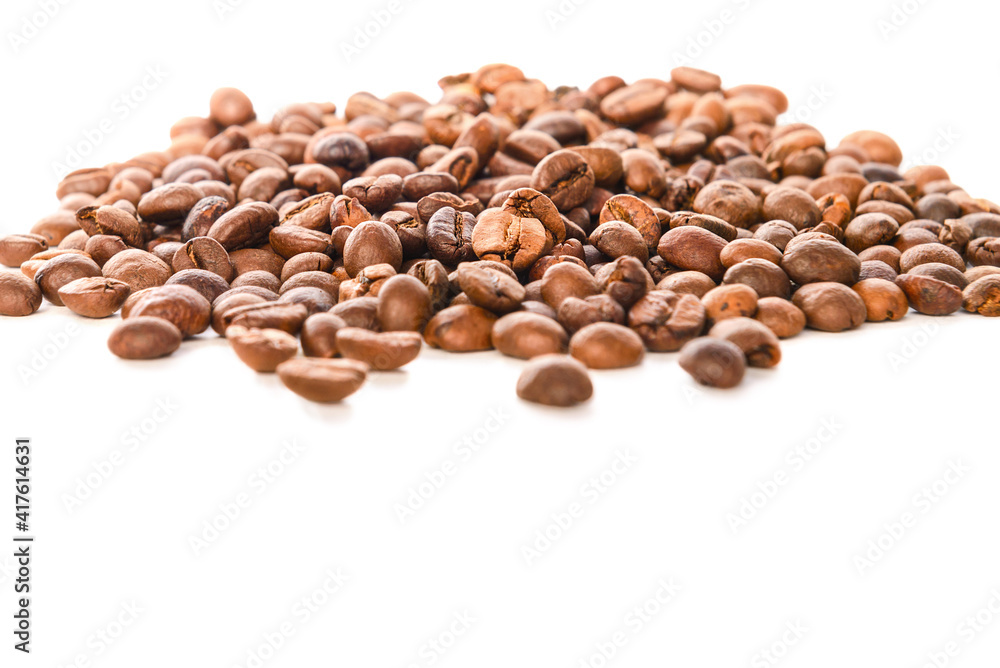 Coffee beans lie on the table on a white background. Coffee beans lie on the table on a white background.