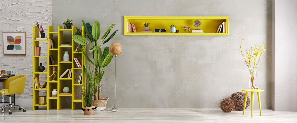 Grey stone wall, room, interior style with yellow niche, green vase of  plant, bookshelf decor. Stock Photo | Adobe Stock