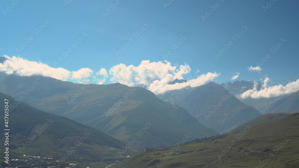 Panoramic view of the green cloudy Caucasus mountains. The camera moves from left to right.