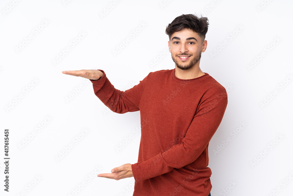 Arabian handsome man over isolated background holding copyspace to insert an ad Arabian handsome man over isolated background holding copyspace to insert an ad