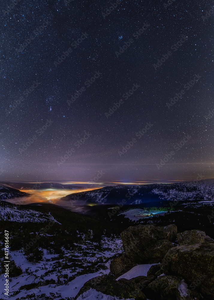 Fototapeta premium night snowy valley with fog and stars