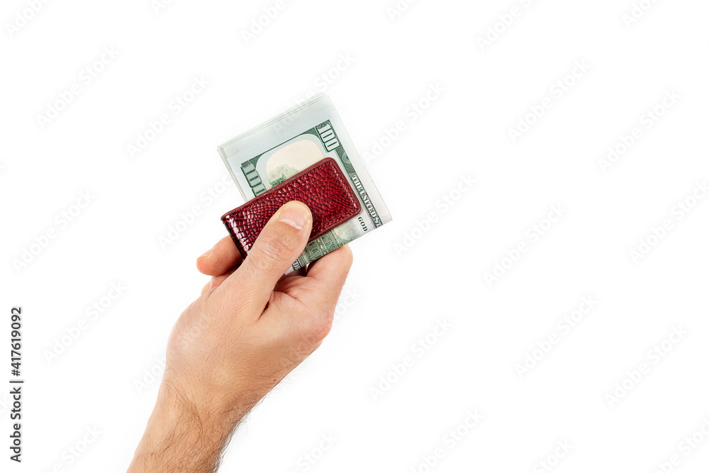 Close up of male's hand holds out dollars clamped with a money clip isolated on a white background Close up of male's hand holds out dollars clamped with a money clip isolated on a white background