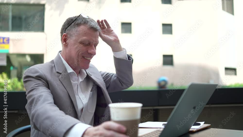 businessman drinking coffee and working business with online community by laptop. day starting at coffee cafe for working success, professional business worker in suit, shot slow-motion businessman drinking coffee and working business with online community by laptop. day starting at coffee cafe for working success, professional business worker in suit, shot slow-motion