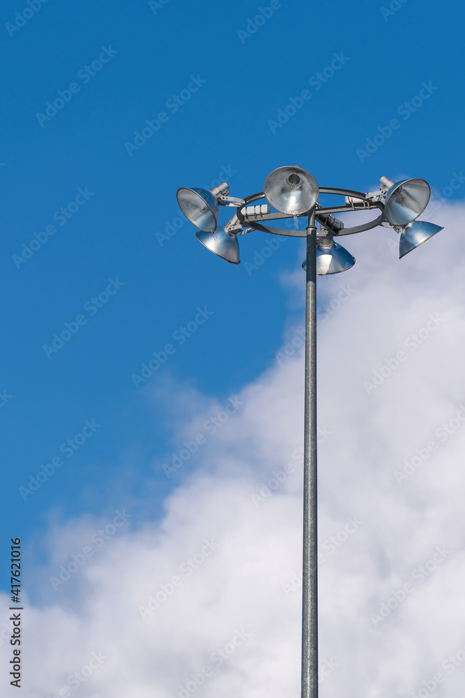 Street lighting. In the foreground is a tall lamppost with six lamps against the background of a cloudy sky. Free space for text. Street lighting. In the foreground is a tall lamppost with six lamps against the background of a cloudy sky. Free space for text.